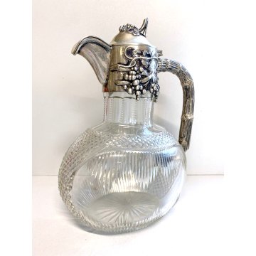 Una caraffa in cristallo molato con due bicchieri con tappo